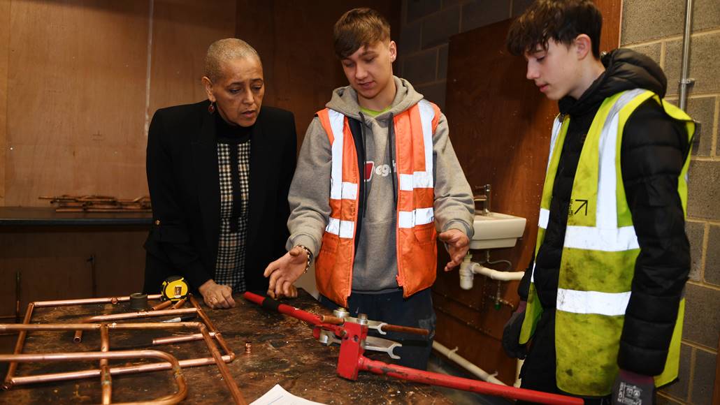 Alison Lowe with two students examining pipework